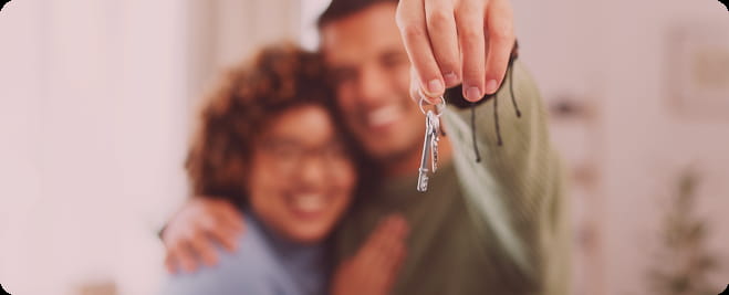 Casal mostrando a chave na mão da contemplação da sua conquista