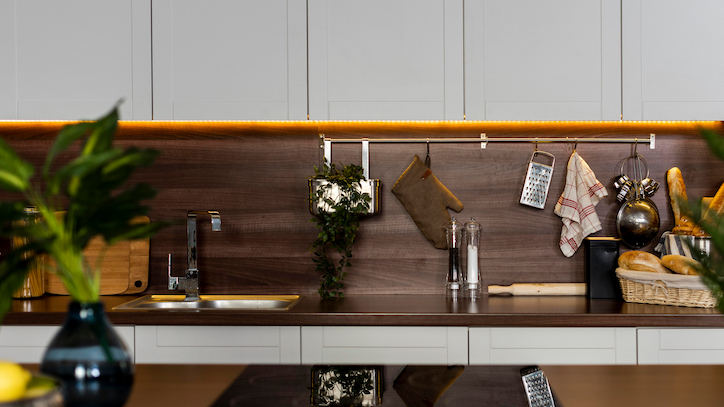 Cozinha compacta com armários até o teto e trilho de spots.